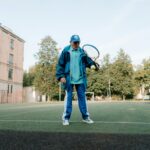 Elderly man enjoying tennis on an outdoor court, promoting active lifestyle.