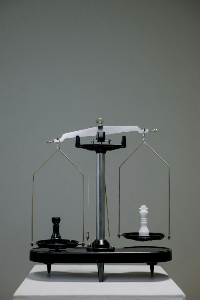 Monochrome chess pieces placed on an antique balance scale symbolizing the concept of equality.